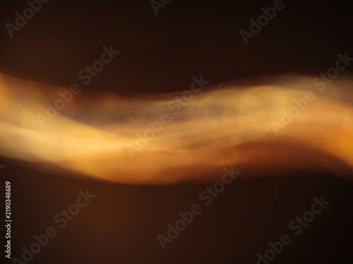 Abstract golden light wave flowing across dark background with soft luminous glow