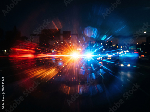 Vibrant red and blue police lights flashing with dramatic light streaks in night city