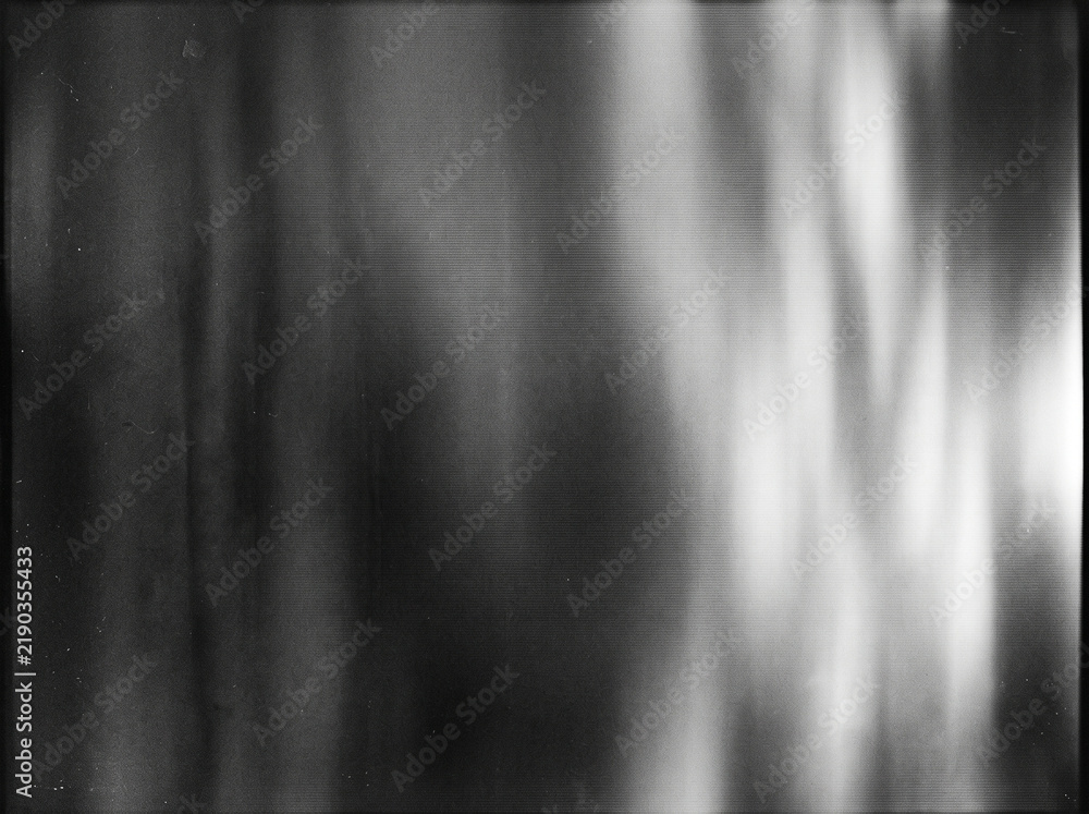 Obraz premium Grungy vintage black and white film scan background with light leaks and grain