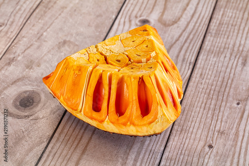 Fotografie Freshly cut jackfruit segment with vibrant orange pulp and fibrous texture on ru