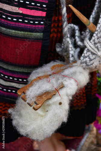 Tapety artystyczne Traditional hand spinning wool with distaff and spindle on folk costume background