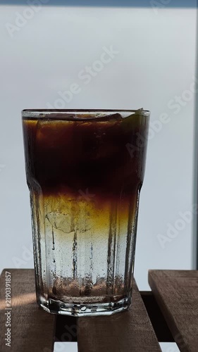 Espresso tonic drink with ice cubes mixing
