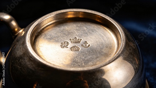 Antique silver cream jug with hallmark stamps on dark velvet, craftsmanship and heritage concept