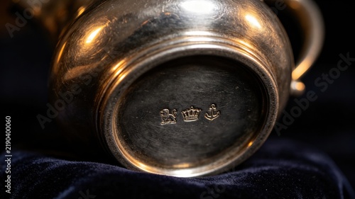 Antique silver cream jug with hallmark stamps on dark velvet, craftsmanship and heritage concept