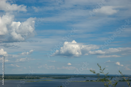 Fotografía Magnificent white cumulus clouds above the Dnipro River under a clear blue summer sky