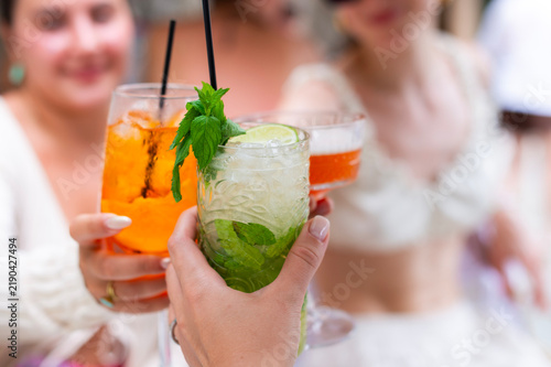 Fotografie Friends toast with cocktails including a mojito, spritz, and coupe drink in Corfu, Greece