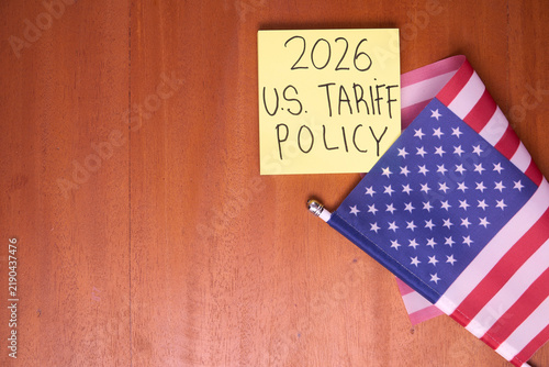2026 U.S. tariff policy note with American flag on wooden table for trade law and import tax concept