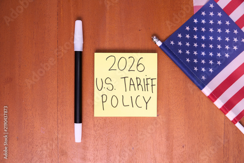 2026 U.S. tariff policy note with American flag on wooden table for trade law and import tax concept
