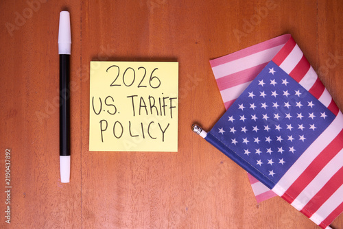 2026 U.S. tariff policy note with American flag on wooden table for trade law and import tax concept