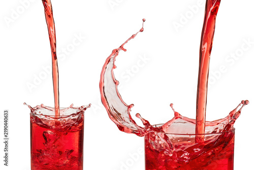 Two glasses being filled with red liquid creating dynamic splashes and droplets against a white background, isolated on a, transparent background