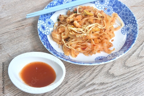 Pad Thai stir fried rice noodles with egg and bean sprout couple garlic chive on plate dipping chili sauce