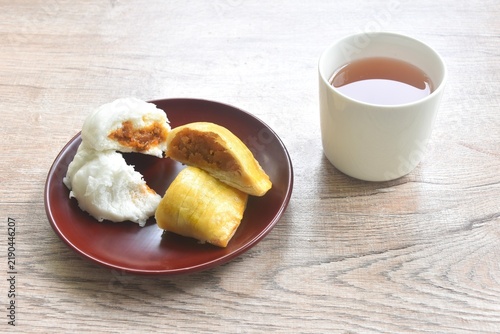 steamed bao Chinese bun stuffing mashed red sweet pork and fried pastry bean on plate eat couple with hot tea
