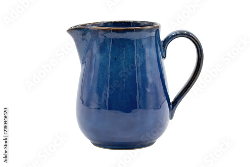 A handcrafted ceramic pitcher with a glossy deep blue glaze and a curved handle for serving liquids or beverages isolated on a transparent background