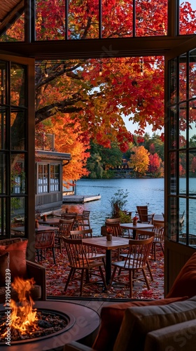 a cozy living space during autumn. The main subject is a seating area with wooden tables and chairs arranged around a fire pit. The fire pit is in the foreground, emitting a warm, orange glow.