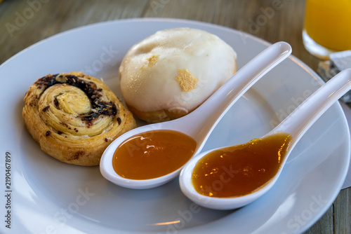 Konstfotografi Delicious hotel breakfast served on an outdoor terrace brad bun jam on porcelain spoons and choocolate pastry
