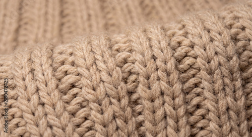 Chunky knit wool texture macro photo of beige ribbed sweater for cozy background