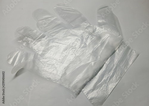 A Pair of Clear Disposable Plastic Gloves on White Background