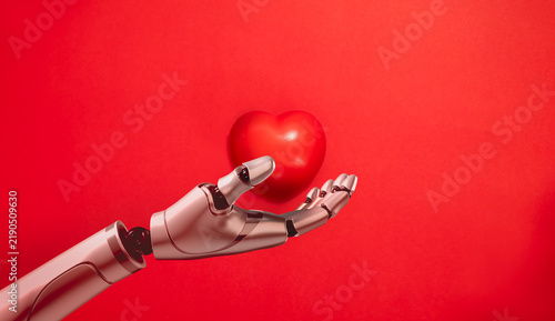Obraz na plátně Robotic hand gently holds a red heart