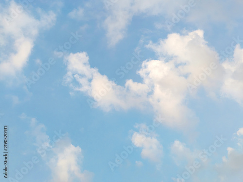 Soft white clouds floating in bright pastel blue sky create gentle and airy backdrop for subtle environmental theme.