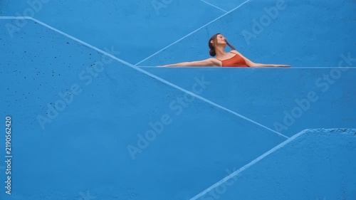 Woman in red dancing on blue stairs