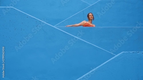 Woman in red dress dancing on blue stairs