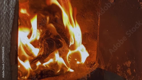 Intense burning of crumpled paper and kindling in the fire inside the cast-iron combustion chamber of the stove