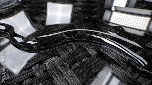 High-detail close-up of resin saturation on carbon fiber layers for aerospace or automotive composite production.
