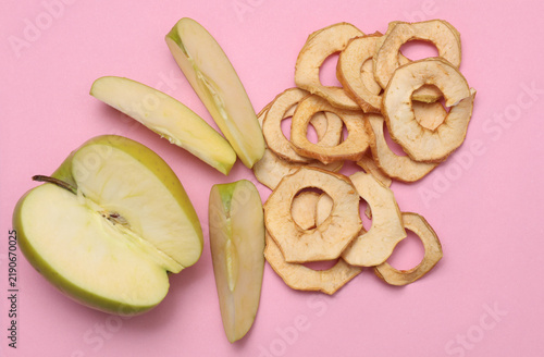 Ripe apples and apple chips on a pastel background