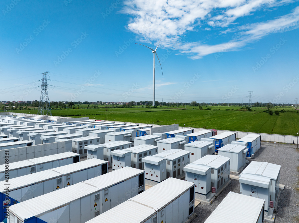 Obraz premium energy storage station and wind turbine under blue sky