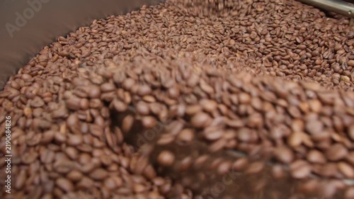 Freshly roasted coffee beans cooling in roaster tray, closeup