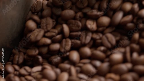 Freshly roasted coffee beans cooling in roaster tray, closeup