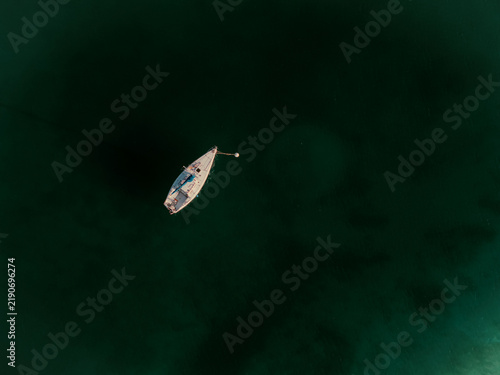 Boat on dark blue green water from a drone