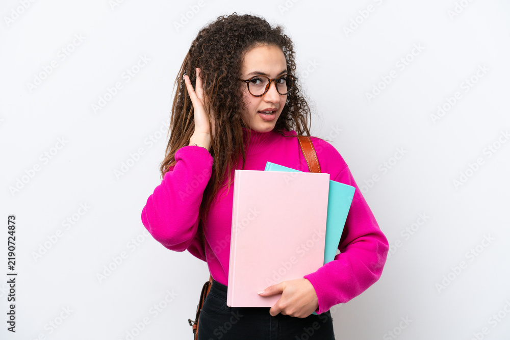 Fototapeta premium Young student Arab woman isolated on white background listening to something by putting hand on the ear