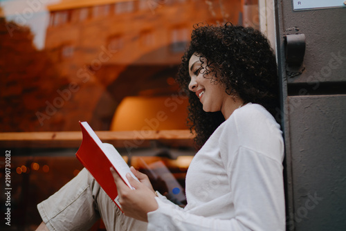 Foto Smiling young woman in round eyeglasses scrolling social media on smartphone scr