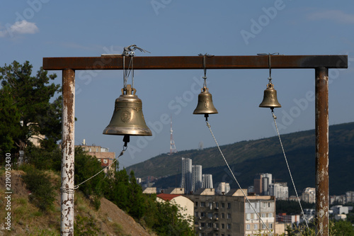 Bild auf Leinwand Commercial stock photo of bronze church bells against an urban landscape