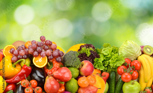 Comprehensive Array of Fresh Fruits and Colorful Vegetables Laid Out on Natural Green Bokeh Background with Copy Space Above for Healthy Eating and Nutrition Banner