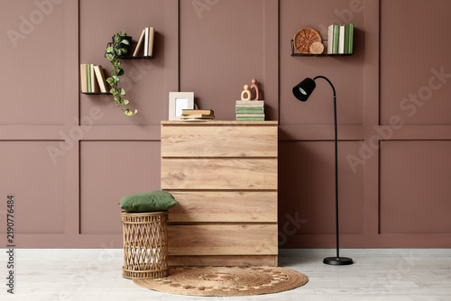 Blurred view of stylish home library with wooden dresser, books and standard ...