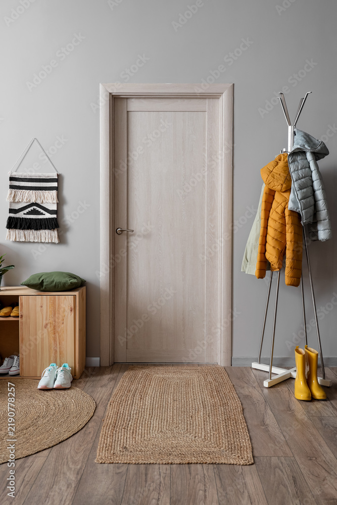 Obraz premium Interior of hallway with shoe stand, door and clothes rack