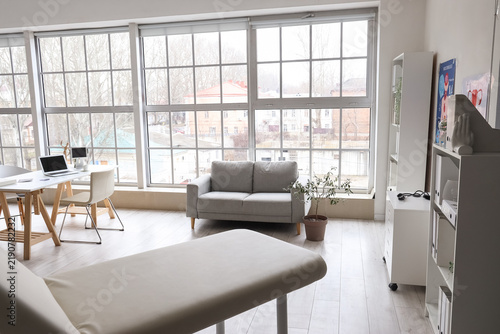 Interior of gynecologists office with sofa and medical couch