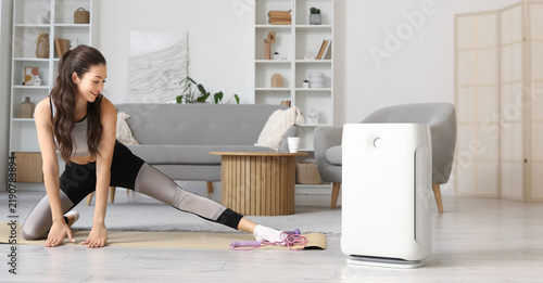 Healthy home environment and indoor air quality, woman exercising with air pu...