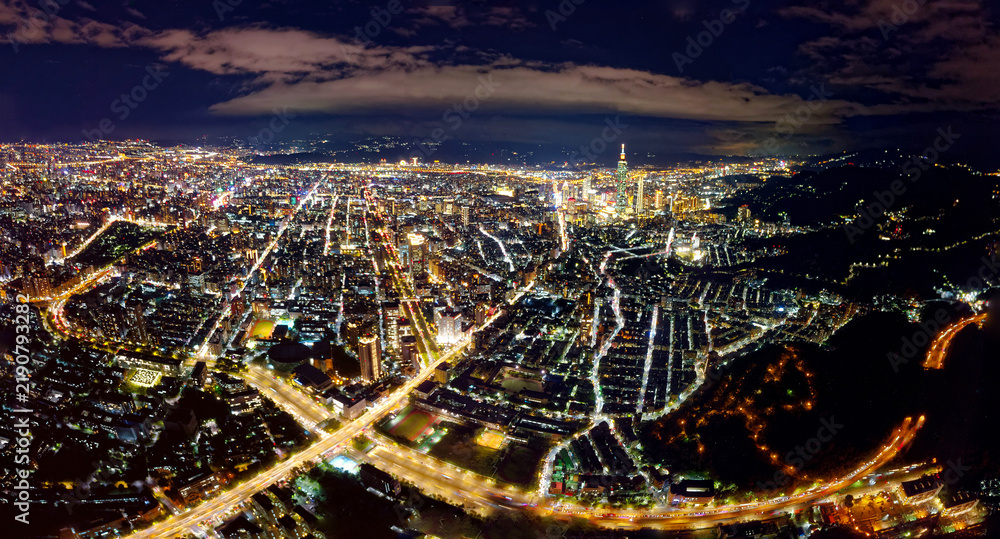 Obraz premium Aerial panorama of Taipei at night, vibrant capital city of Taiwan, with 101 Tower standing amid high-rise buildings in Xinyi Downtown and city lights of the crisscrossing streets dazzling in the dark