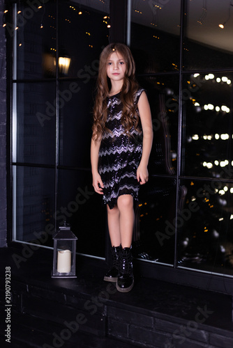 Girl in Sequined Dress Standing Near Lantern with Bokeh City Lights Background