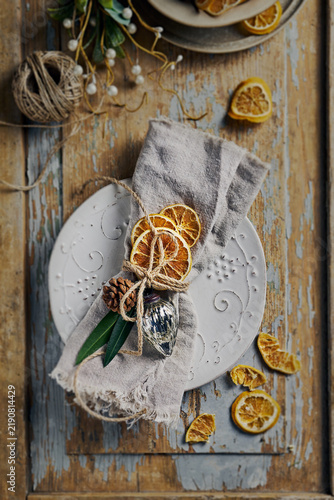 Top view of rustic Christmas table setting with dried oranges