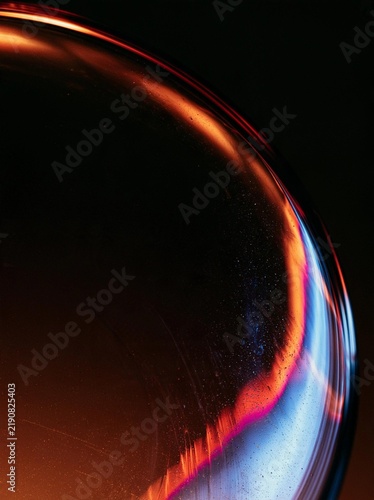 Close-up of a sphere with a dark background. the sphere appears to be made up of a series of curved lines that form a wave-like pattern.
