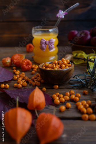 Quadro su tela Ripe sea buckthorn berries in wooden scoop on rustic table
