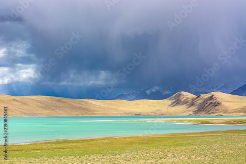 Turquoise waters of Kyagar Tso lake under a leaden sky in Ladakh
