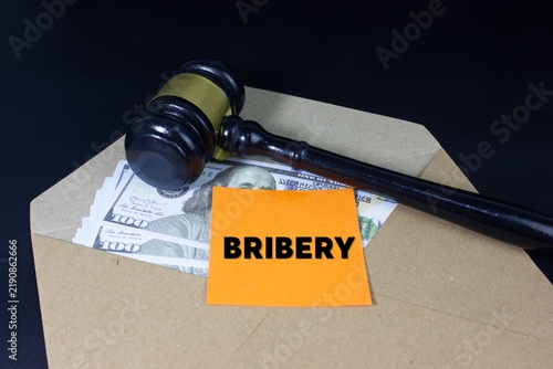 Fotografie envelope filled with money beside a legal gavel and BRIBERY text, symbolizing co