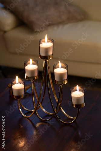 Golden candelabra with five lit candles on a dark table