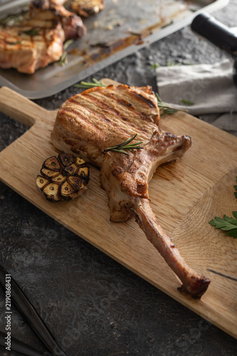 Grilling tomahawk pork chop with roasted garlic and rosemary