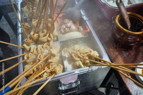 Фотография Steaming fish cake skewers simmer in a rich broth at an authentic Asian street f